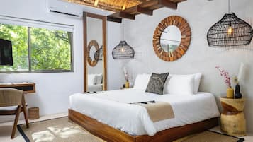 Quarto moderno com uma cama grande, uma escrivaninha e uma televisão.