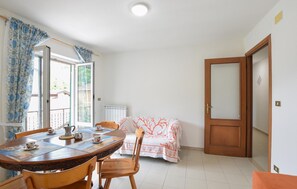 A dining area with a round table, chairs, a coffee pot, and a breakfast setting. - Cozy apartment in Varese Ligure with WiFi (Varese Ligure)