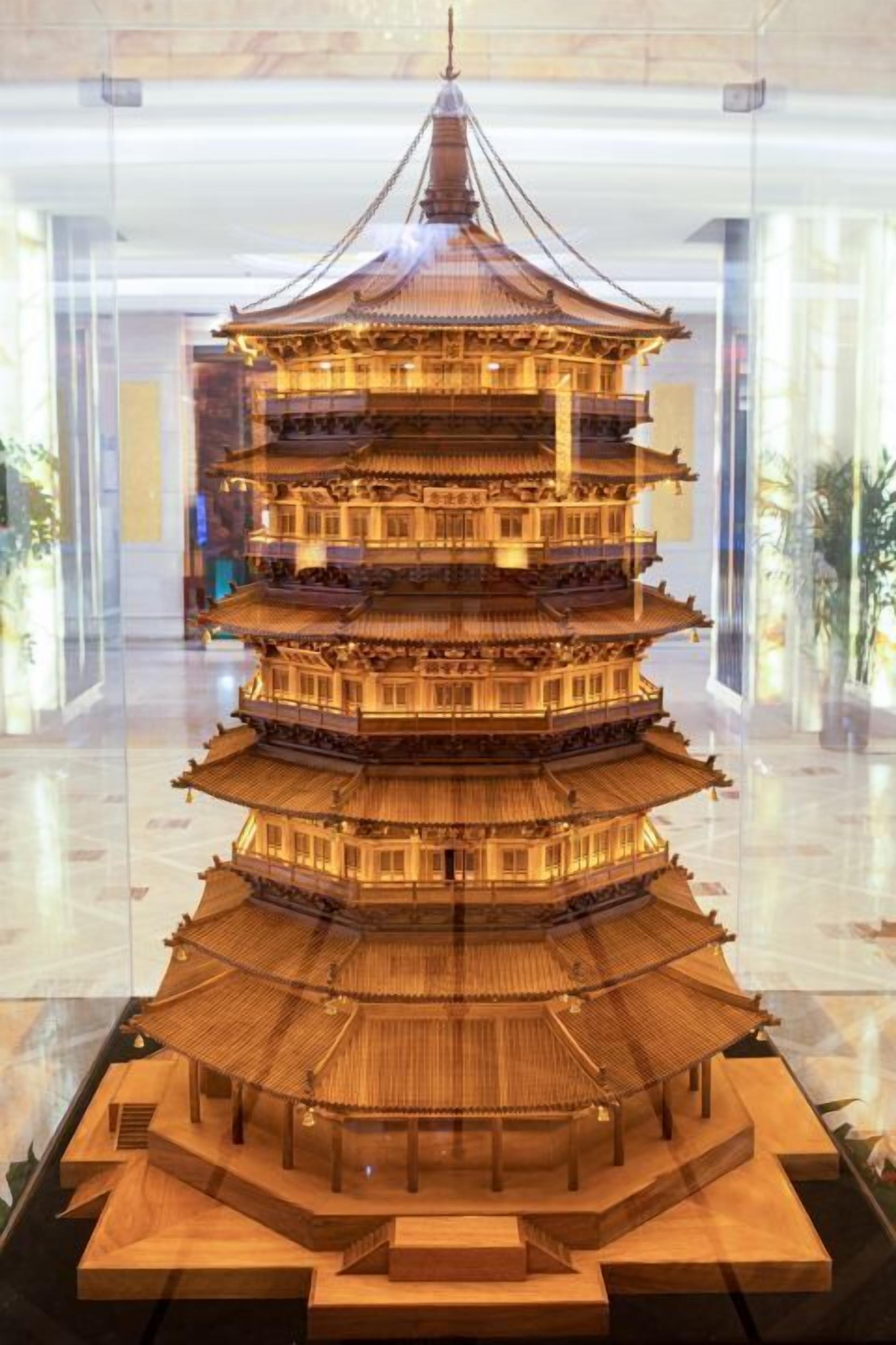 A multi-tiered pagoda-style structure with a central spire, surrounded by a wooden base.