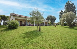 Ein Haus mit Ziegeldach, einer überdachten Veranda und einem gepflegten Rasen.