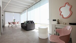 A modern interior with a grey sofa, pink chairs, a white table, and a large window. - Amazing home in Salemi (Salemi)