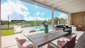 A modern outdoor living area with a pool, a dining table, and seating. - Amazing home in Salemi (Salemi)