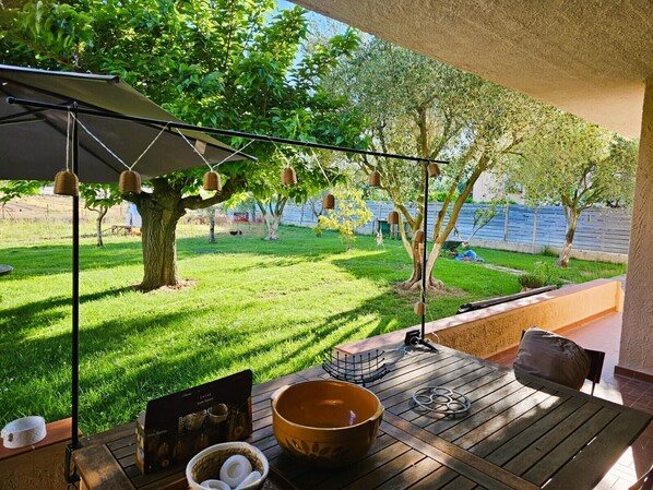 A patio with a table, a bowl, and a menu. - Le Petit Maraîcher: Terrace & Total Tranquility (Puget-sur-Argens)