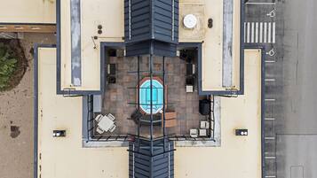 An aerial view of a building with a rooftop pool, surrounded by a fence, and a wheelchair-accessible area on the right.