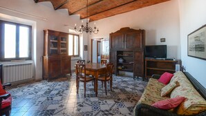 Un vaste espace de vie comprenant une table à manger, des meubles en bois, un canapé et un téléviseur.