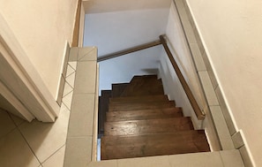 A wooden staircase with a handrail, leading to an upper floor.