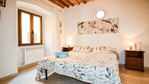 A bedroom with a bed, a window, a radiator, and a wall-mounted artwork. - Gorgeous apartment in Monterotondo Marittimo (Monterotondo Marittimo)