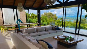 Ein modernes Wohnzimmer mit einem Ecksofa, einem Holztisch und einem Essbereich mit einer Bank und Stühlen.