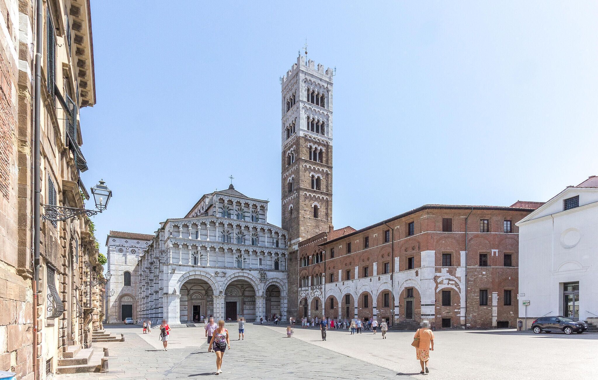A historic square with a prominent bell tower and a cathedral with intricate architecture.