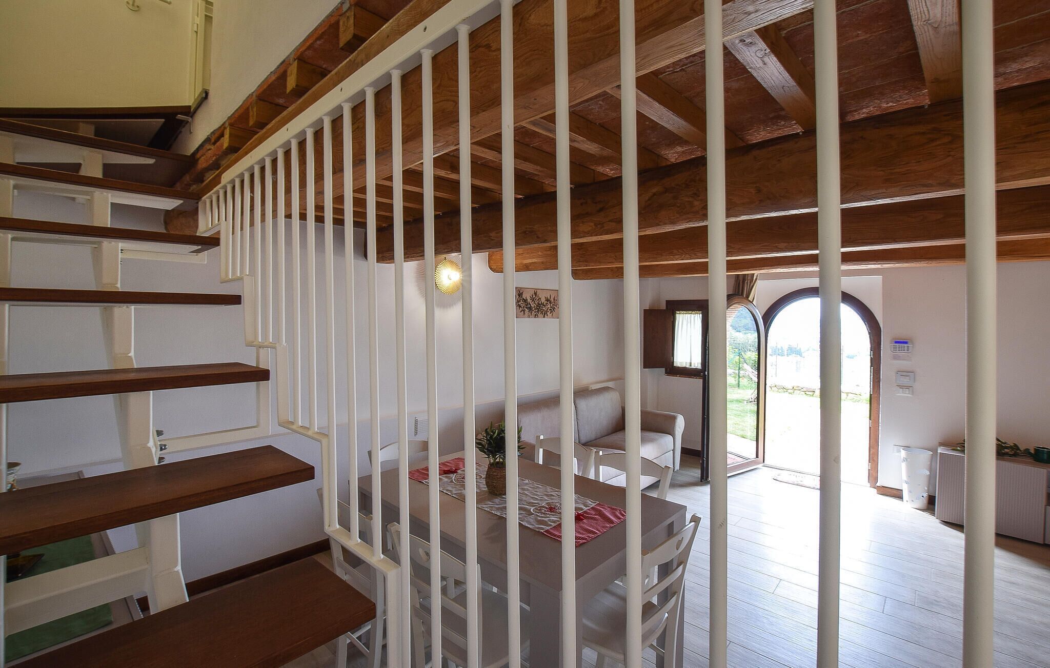 Un escalier avec des rampes blanches menant à un espace repas comprenant une table et des chaises.