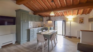 Una cocina con una mesa de comedor, sillas y un techo con vigas a la vista.