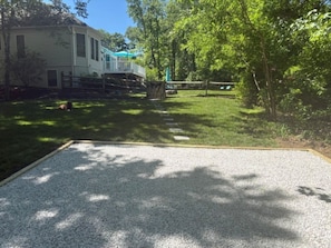 A residential property with a gravel driveway, a fenced yard, and a house with a blue roof. - Poolside Annapolis Retreat for Mid-Term Stays! (Annapolis)