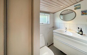 Un bagno con lavandino, specchio e servizi igienici bianchi.