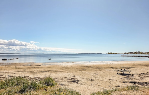 A beach with a picnic table and calm water. - Beautiful home in Tolvsrød (Tolvsrød)