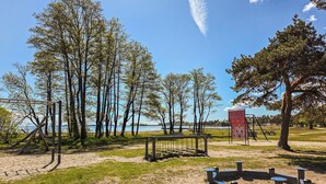 Ein Park mit Schaukeln, einer Kletterkonstruktion und Picknicktischen.