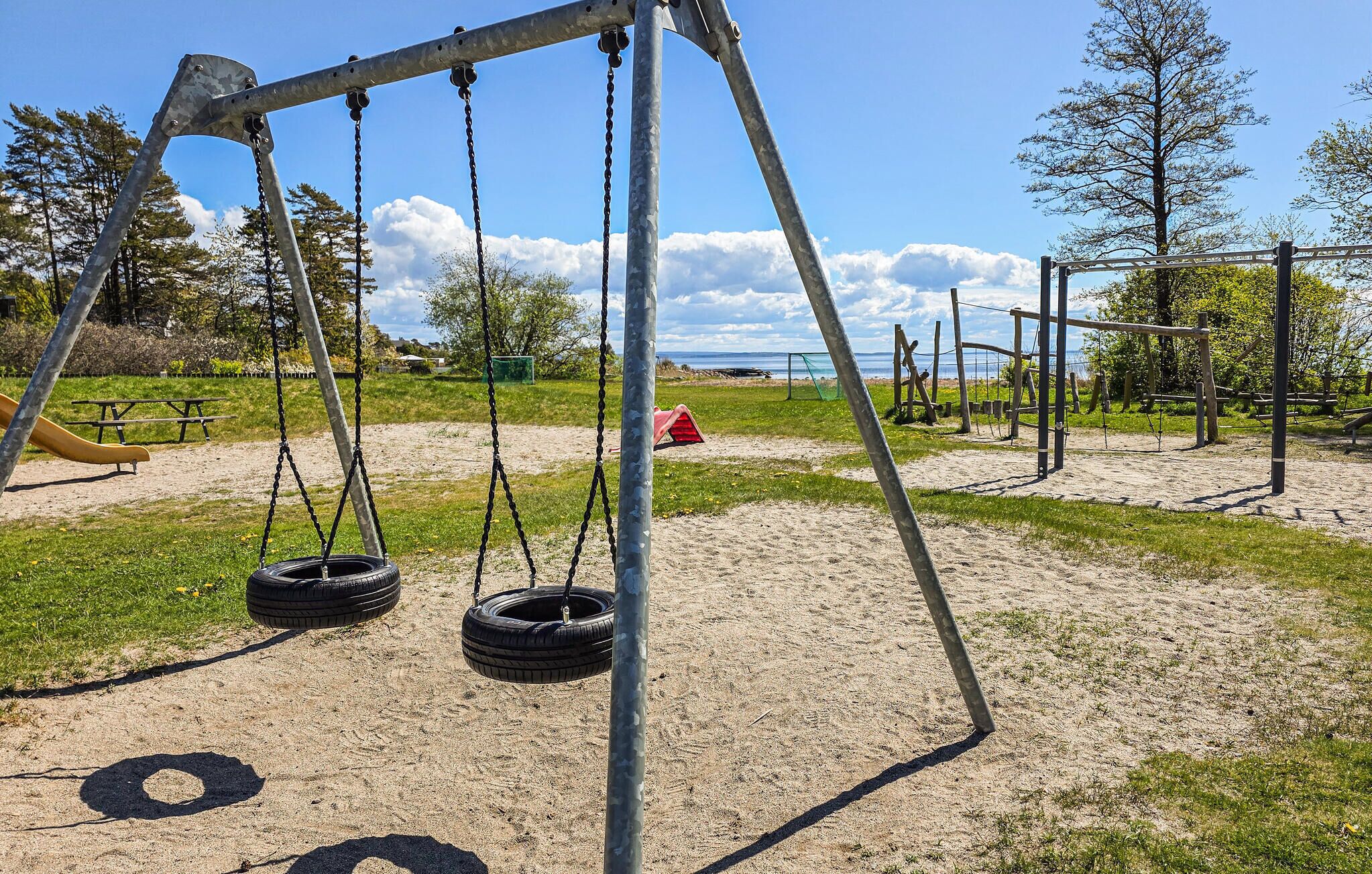 A playground with swings, a slide, and tire swings.
