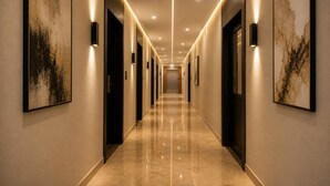 A long, well-lit hallway with doors on both sides, leading to a distant door at the end.