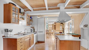 Une cuisine moderne avec des meubles en bois, un îlot central et un coin repas avec des chaises.