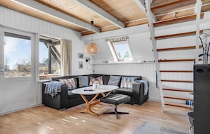 Ein modernes Loft mit Schlafgalerie, Essbereich und großem Fenster.