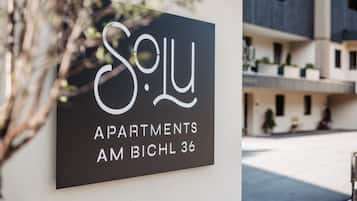A sign for 'S. L. Apartments' with a modern architectural style.