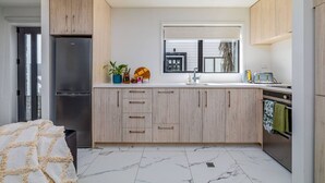 Una cucina moderna con frigorifero integrato, lavello e finestra.