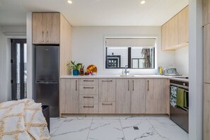 Eine moderne Küche mit Einbaukühlschrank, Spüle und Fenster.
