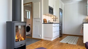 Eine moderne Küche mit Einbauherd, Mikrowelle und Backofen, ein Hauswirtschaftsraum mit Waschmaschine und eine gemütliche Sitzecke mit Teppich.