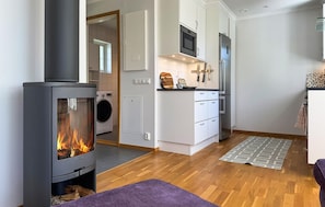 A modern kitchen with a built-in stove, microwave, and oven, a laundry room with a washing machine, and a cozy seating area with a rug. - Stunning home in Gotlands Tofta (Gotlands Tofta)