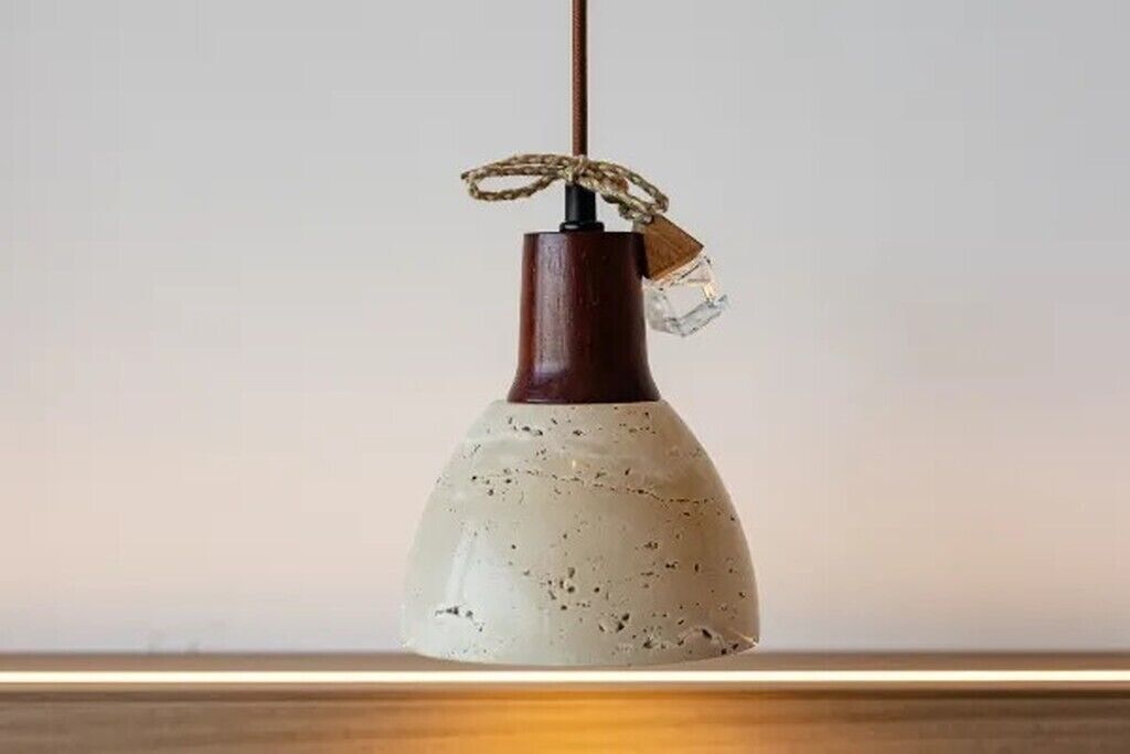 A pendant light with a textured ceramic shade and a wooden base.