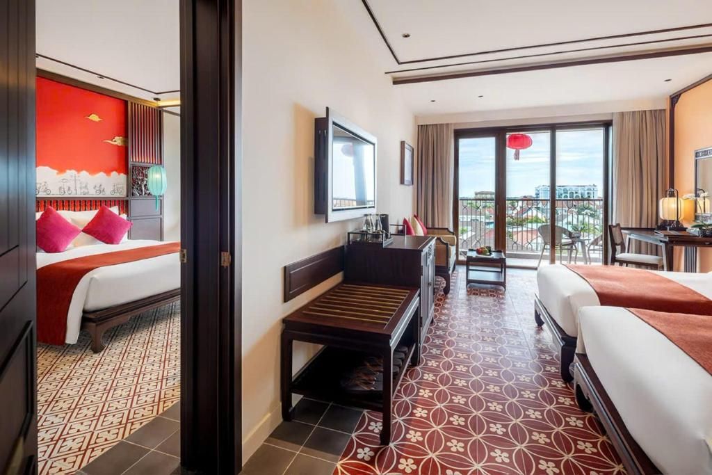 A hotel room with a bed, a desk, a chair, and a view of the outside.