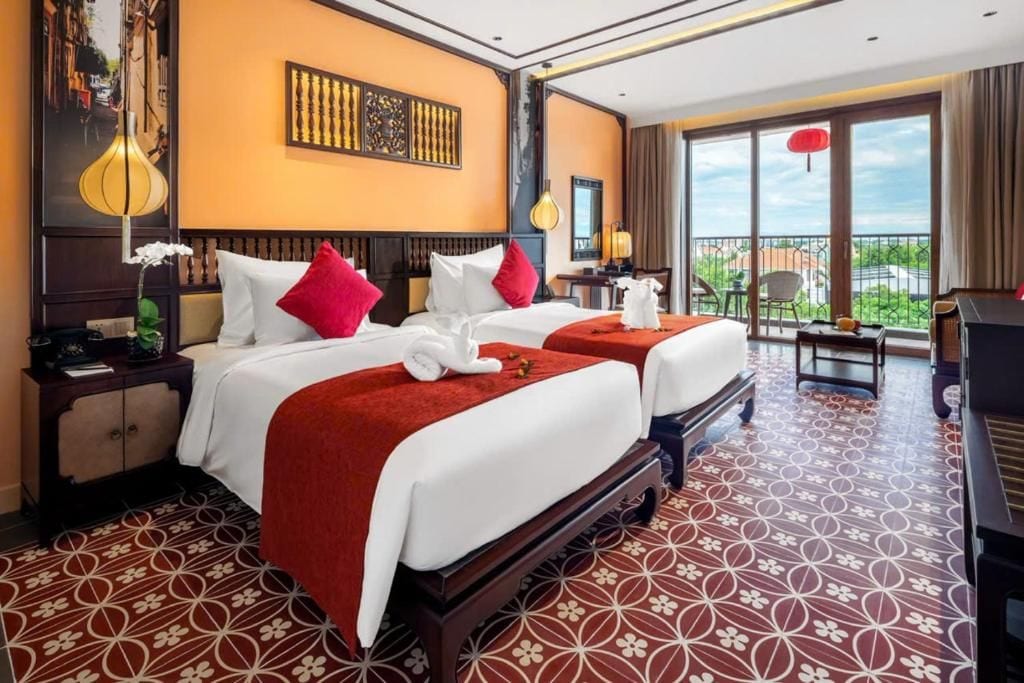 Une chambre d’hôtel avec deux lits, un balcon et une vue sur la ville.