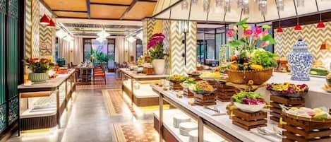 A buffet area with multiple serving stations, a central walkway, and decorative lighting.