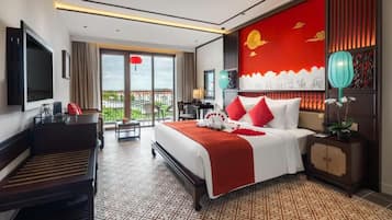 Ein Hotelzimmer mit Bett, Schreibtisch, Fernseher, Balkon und Blick auf die Stadt.