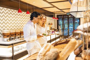 A restaurant interior with a modern design, featuring a counter with food items and a patterned wall. - HOI AN MOON PREMIUM BOUTIQUE HOTEL & SPA (Da Nang)