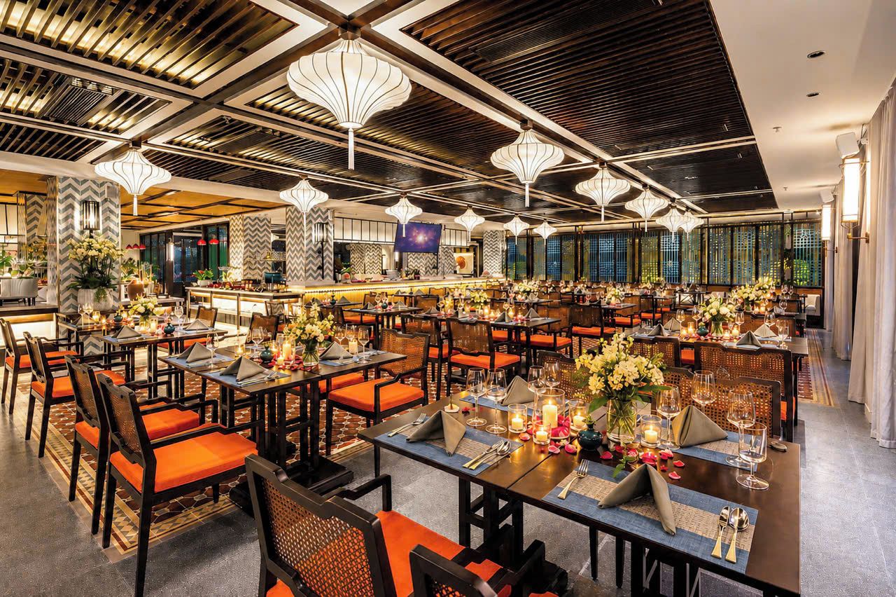 Un restaurante con varias mesas, sillas y una zona de bar.