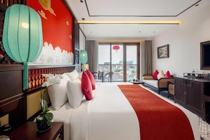 Un cuarto de hotel con una cama grande, vistas de la ciudad, un balcón y un televisor.