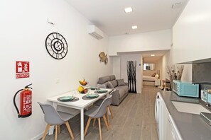 Una cocina moderna con microondas, lavamanos y comedor con mesa y sillas.