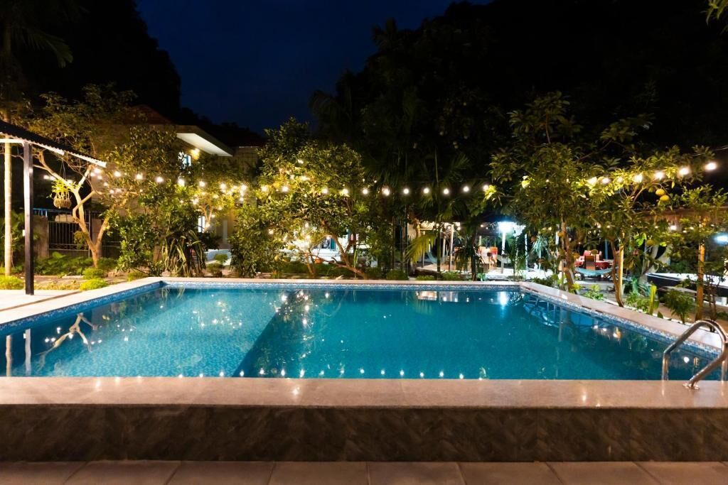 Una piscina al aire libre, sombrillas, sillones reclinables de piscina