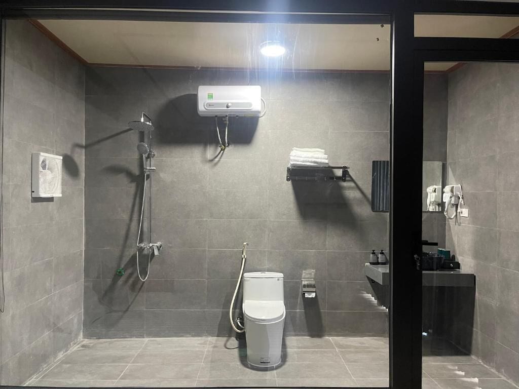 Un baño moderno con ducha, inodoro y barra para toallas.