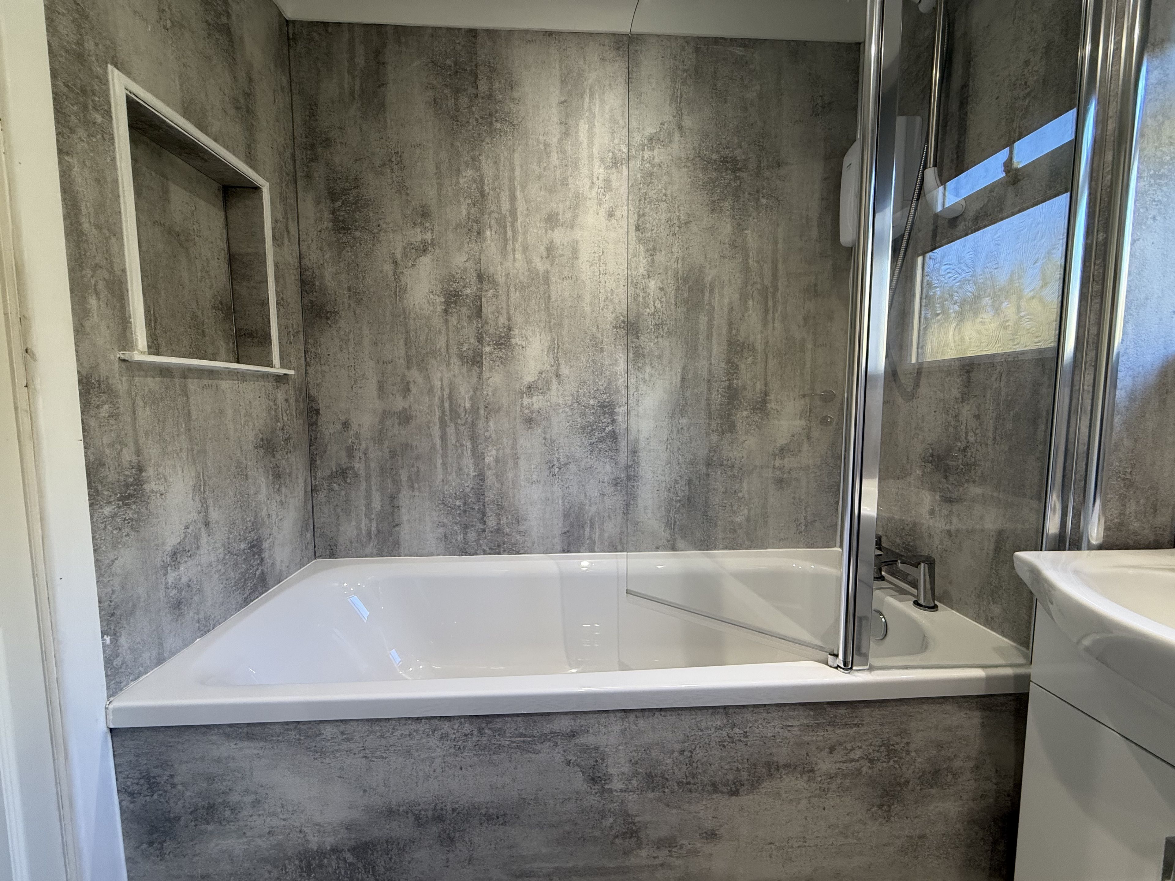 A modern bathroom with a bathtub, a shower enclosure, and a sink.