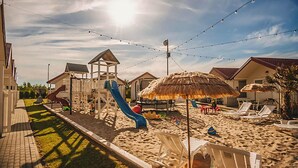 A beachside resort with a playground, thatched umbrellas, and lounge chairs. - Amazing home in Wicie with WiFi (Wicie)