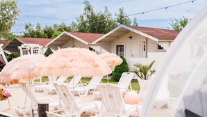 Outdoor lounge chairs, a beach umbrella, and a building with a red roof. - Amazing home in Wicie with WiFi (Wicie)