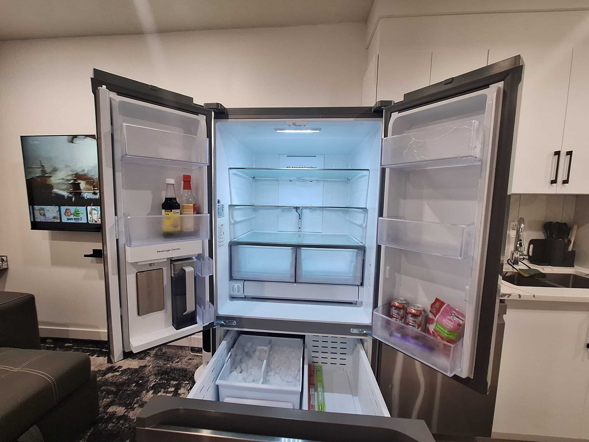 A compact refrigerator with a beverage center, ice maker, and a freezer drawer.