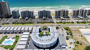A coastal hotel with multiple high-rise buildings, a swimming pool, and a beachfront view.