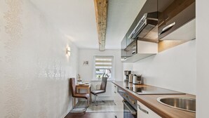 Una cocina compacta con encimera de madera, horno integrado y pileta de acero inoxidable.