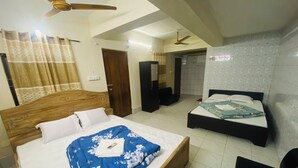 A hotel room with two beds, a ceiling fan, a wooden headboard, and a tiled floor. - HOTEL Al-FAHAD INT.LTD. (Dhaka)