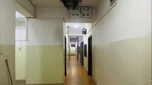 A hallway with a ceiling light fixture, a door at the end, and a window on the right wall. - HOTEL Al-FAHAD INT.LTD. (Dhaka)
