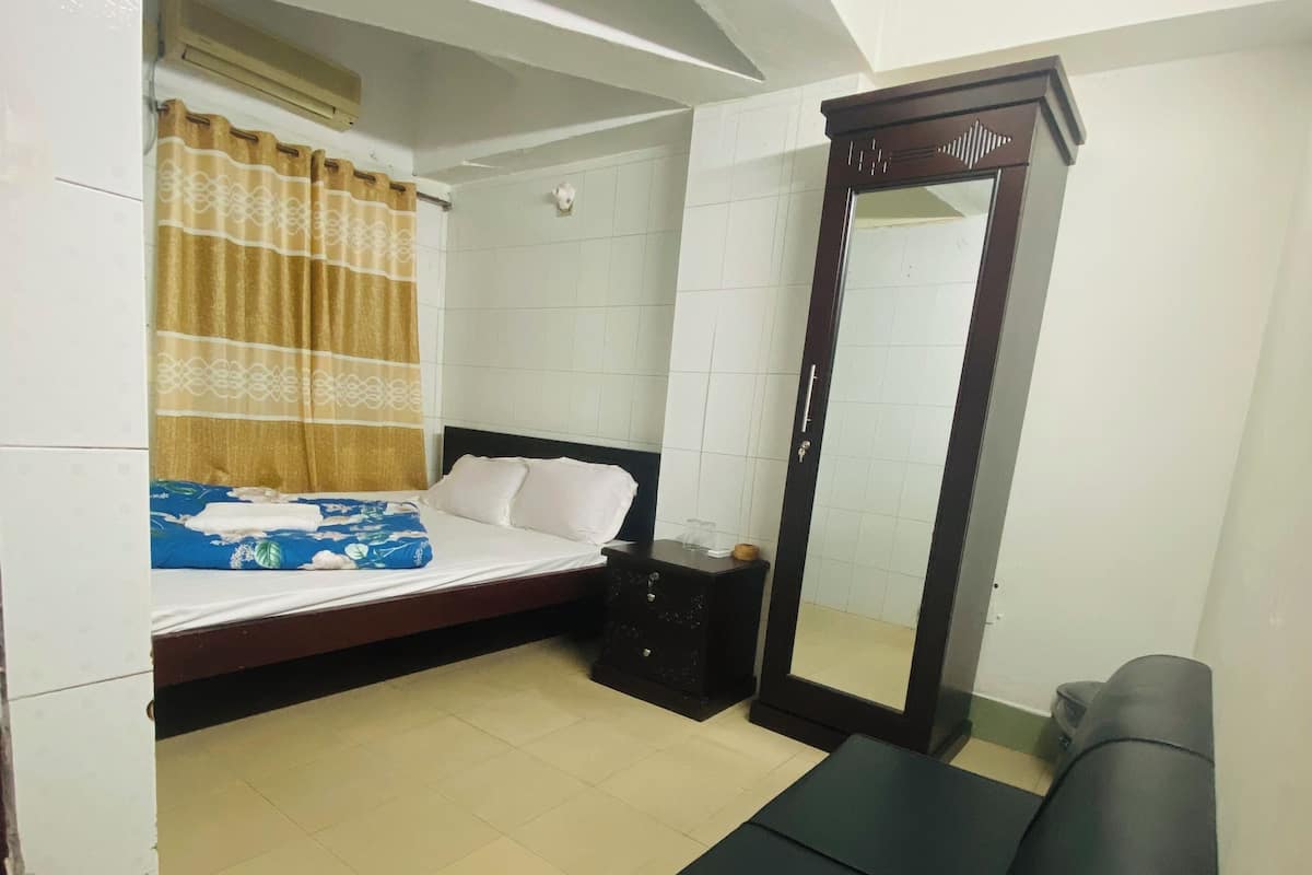 A bedroom with a bed, a dresser, a mirror, and a bench.