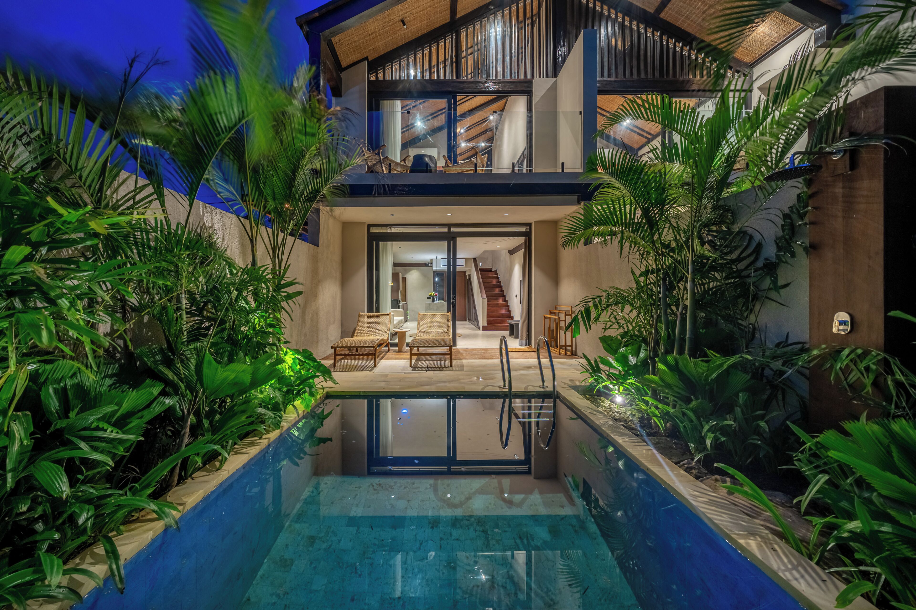 A modern house with a swimming pool, a staircase, and a balcony.