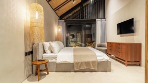 Quarto moderno com cama, mesa de cabeceira, televisão e um armário de madeira.
